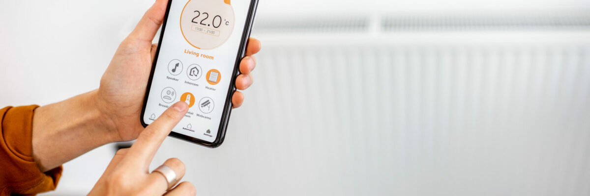 Controlling radiator heating temperature with a smart phone, close-up with radiator on the background. Concept of a smart home and mobile application for managing smart devices at home